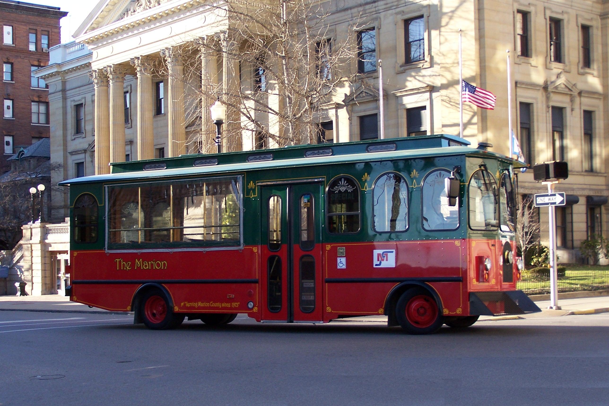 red trolley parked in front of the courthouse