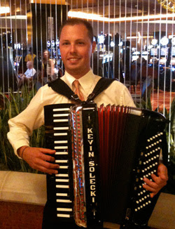 man in white shirt and red tie holding an accordion