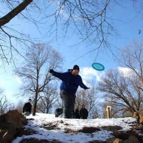 man throwing a disc with snow on the ground