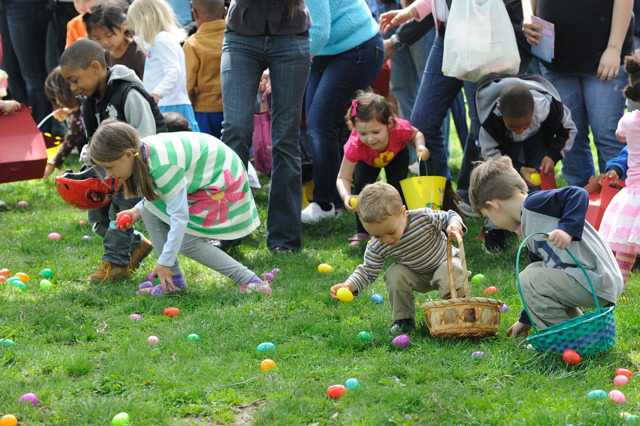 children holding baskets picking up Easter eggs