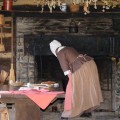woman preparing food in front of an open hearth