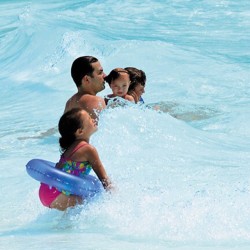 family swimming in a wave pool