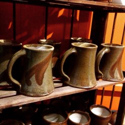 hand made mugs with handles sitting on a shelf
