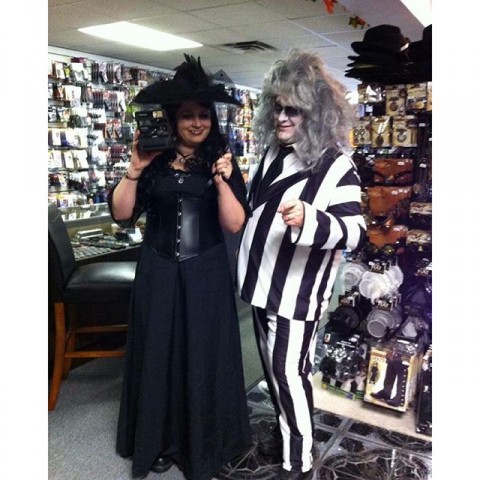 woman dressed as a witch and man in black and white stripes