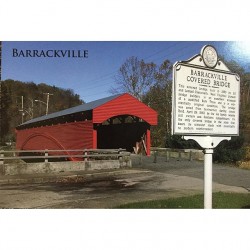 a red covered bridge with a historical sign in front