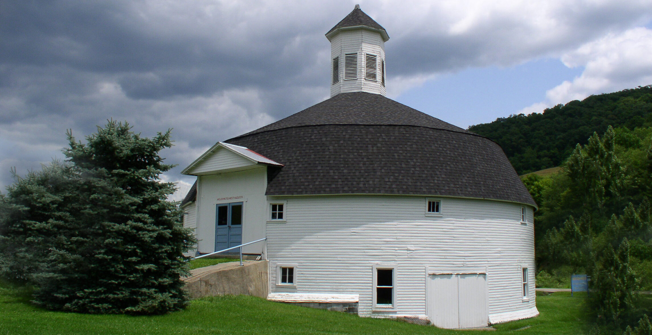 white round barn with dark shingled roof