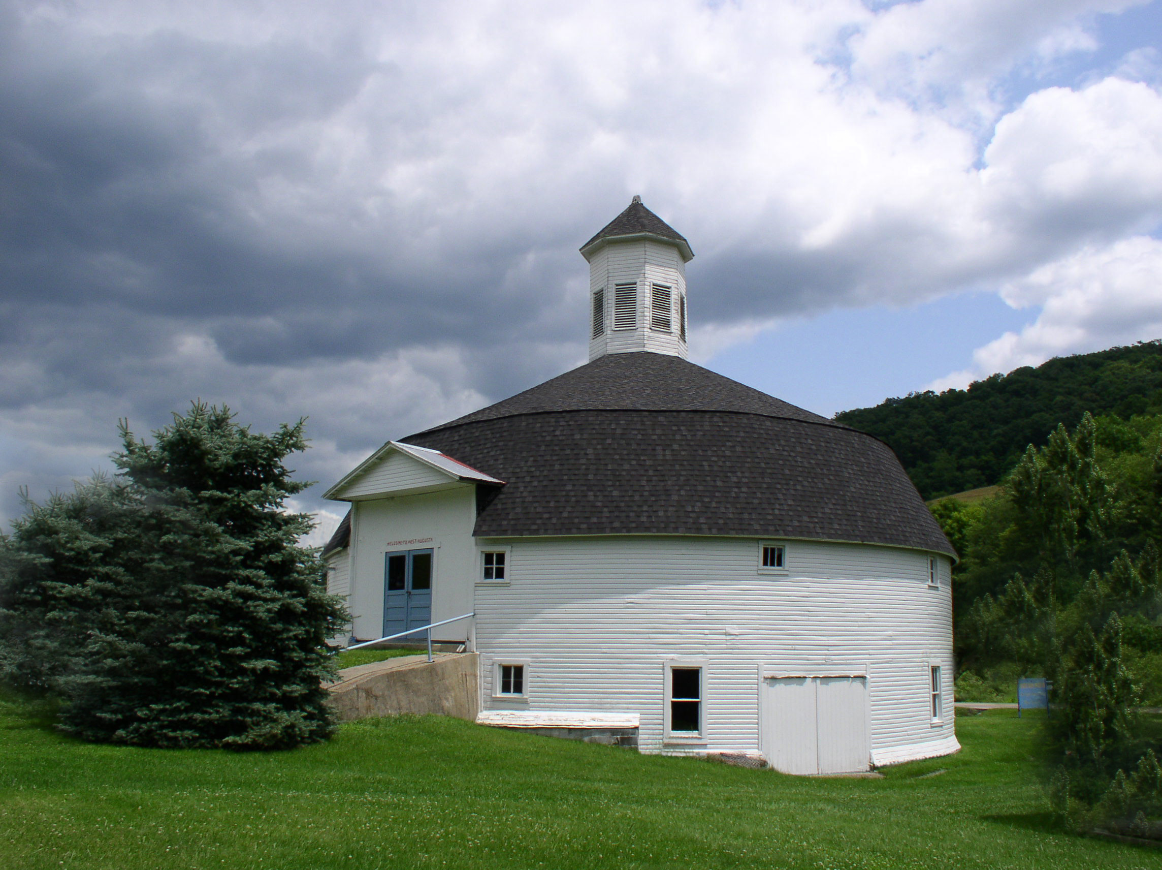 white round barn with dark shingled roof
