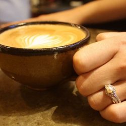 woman hand holding a brown ceramic mug of coffee
