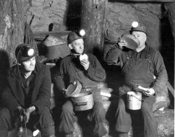 black and white photo of coal miners eating