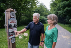 man and woman looking at a sign on a rail trail