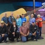 people in front of large guitar