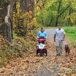 family walking dog on trail in the fall