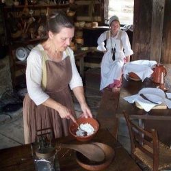 woman dressed in colonial period clothing making soap