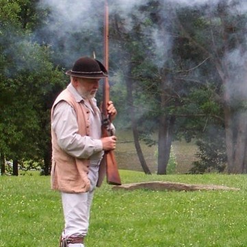 18th century male reanactor holding a rifle