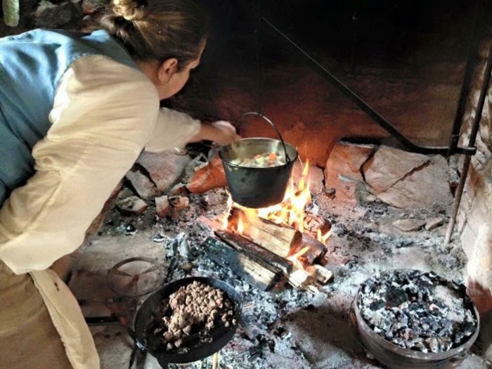 woman cooking over hearth