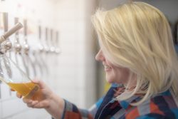 woman pouring beer from a tap