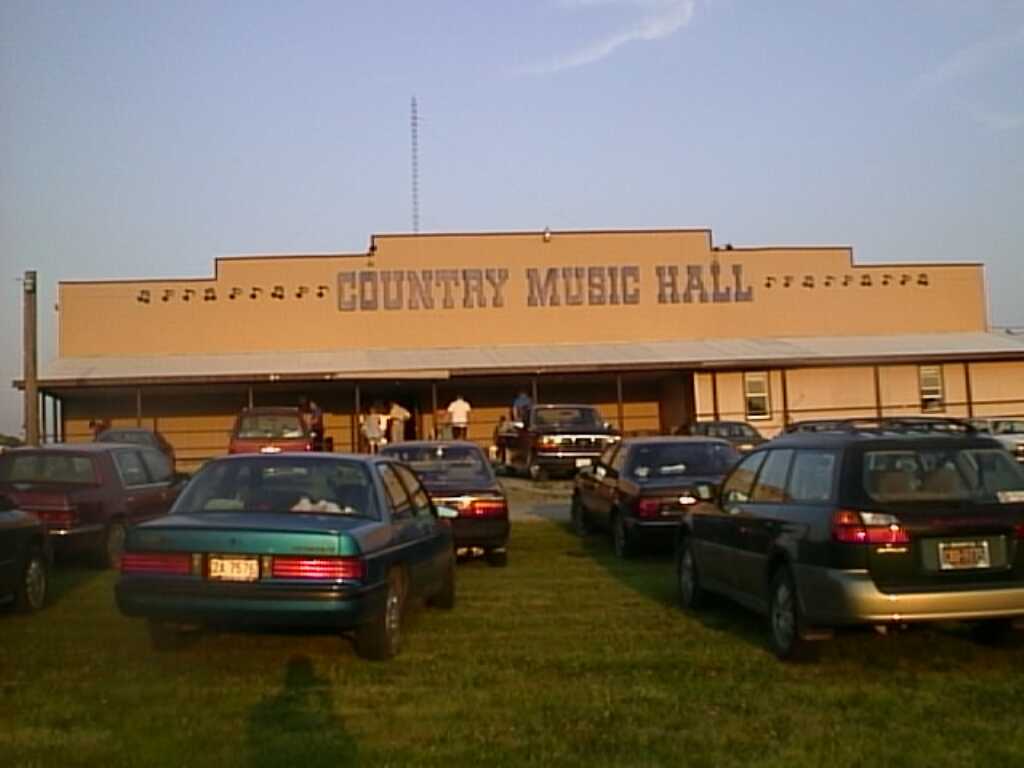 large music hall with cars parked in front of building
