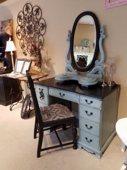 antique vanity with oval framed mirror and chair