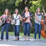4 female bluegrass band holding string instruments