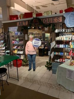 woman holding Small Business Saturday sign in front of antique store 