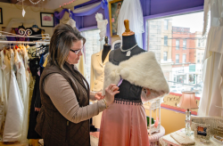 woman looking at a fur shawl on a mannequin