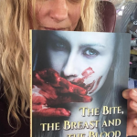 long blond haired woman holding a book about a vampire