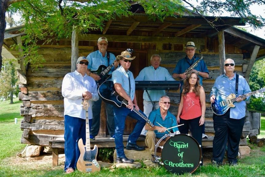 8 people standing outside holding instruments