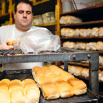 man wrapping loaves of pepperoni rolls