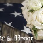 American flag with white roses beside it
