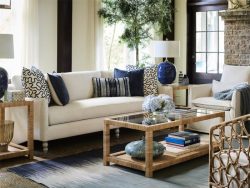 living room display with cream colored couch with blue and white pillows and a coffee table with decorations