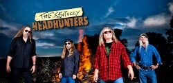 four men of The Kentucky HeadHunters standing outside with a fire burning in the background