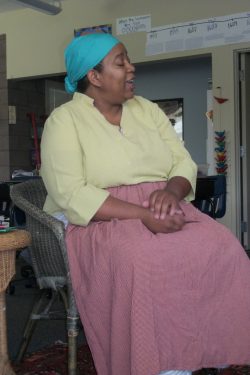 African American woman sitting wearing clothing worn by a slave woman