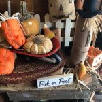 assorted primitive fall decorations such as pumpkins, jack-o-lantern faces