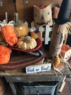 assorted primitive fall decorations such as pumpkins, jack-o-lantern faces