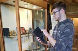 man holding a black boot while standing in front of a display case filled with Civil War artifacts