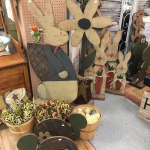 display of wooden flowers, bunnies, and turtles at a craft show