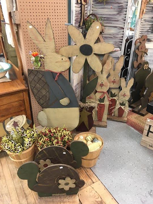 display of wooden flowers, bunnies, and turtles at a craft show