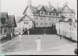 old photo of people playing tennis on a lawn