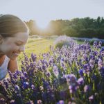 woman beside a lavender plant as the sun is setting