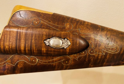 decorative metal inlay in a rifle handle