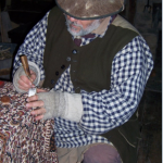 man dressed in frontier clothing working on a powerhorn