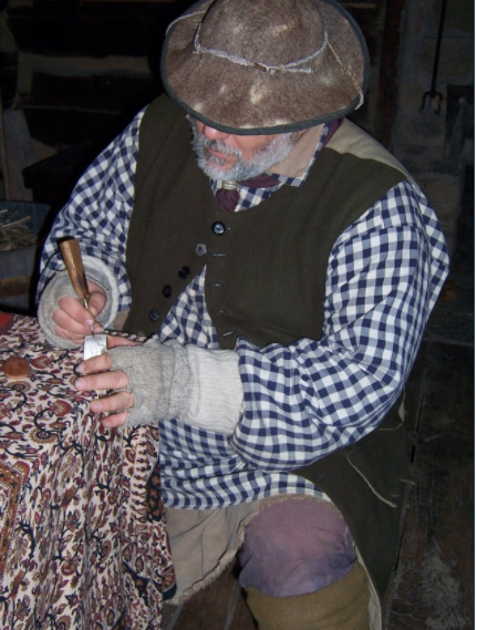 man dressed in frontier clothing working on a powerhorn