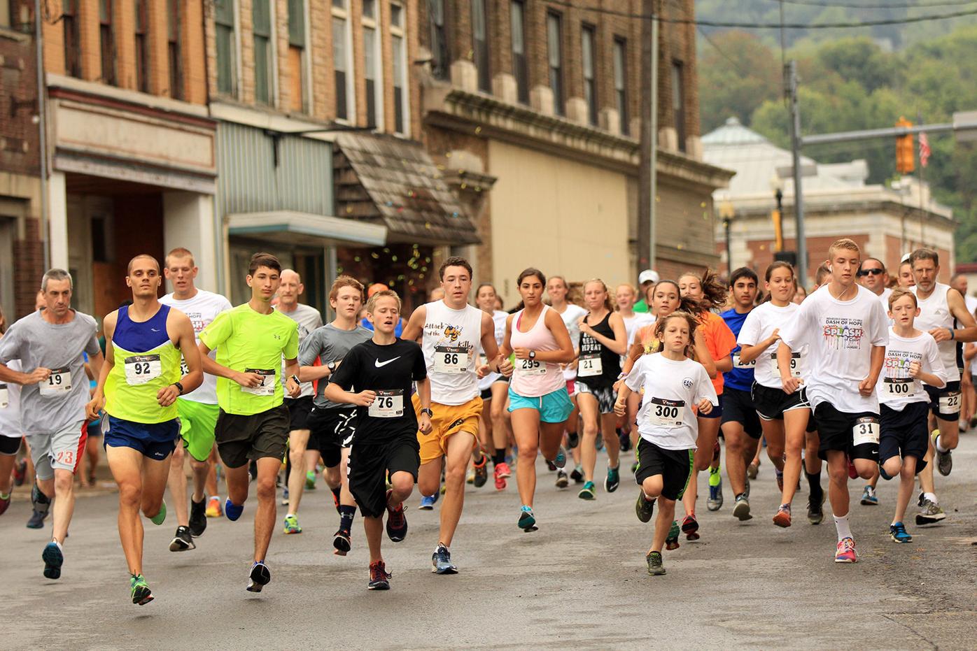 people participating in a running race through a downtown