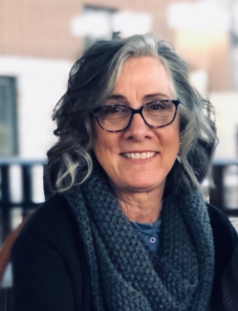 woman wearing glasses with blue shirt and scarf