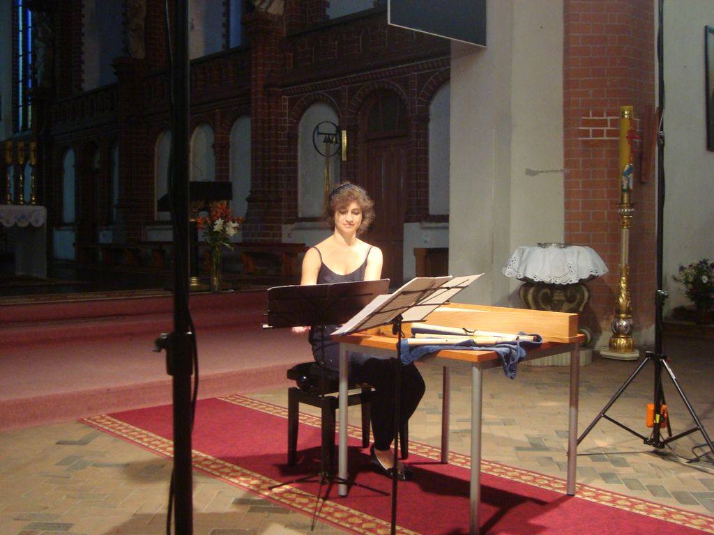 woman sitting in front of a harpsichord