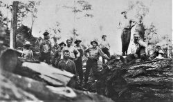 old photo of men standing on large rocks