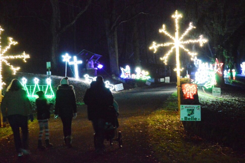 people walking through Christmas lights