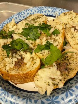 Bread topped with anchovy, cheese and parsley 