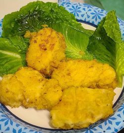 Fried Baccala on a plate with lettuce leaves