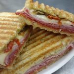plate of panini sandwiches with ham, white cheese and roasted red peppers